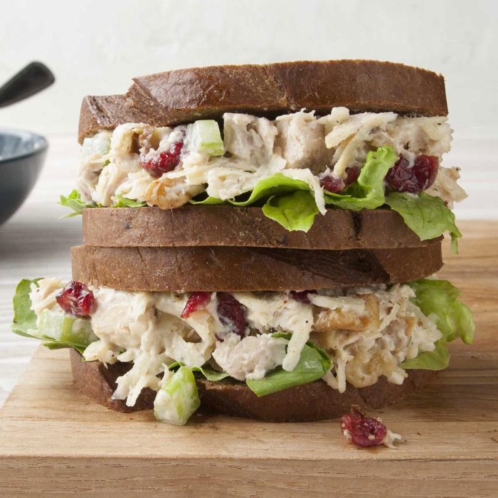 A food worker prepares chicken salad sandwiches